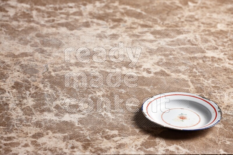 A vintage metal plate on beige marble background