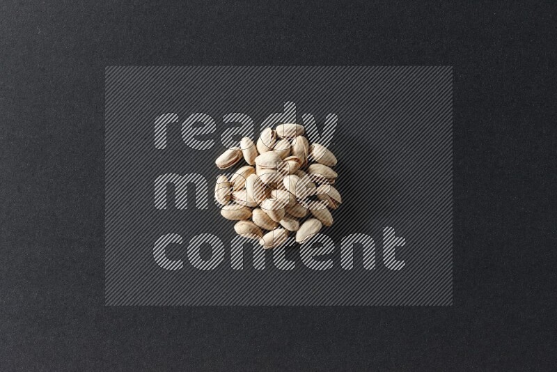 A bunch of pistachios on a black background in different angles