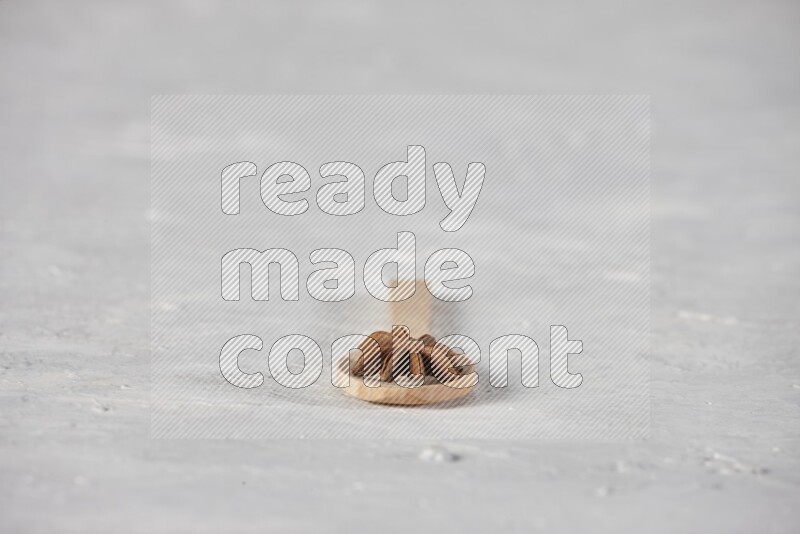 Star Anise in a wooden spoon on white flooring