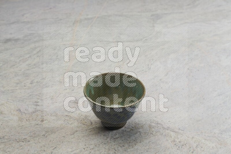 A multicolored pottery bowl on grey marble background