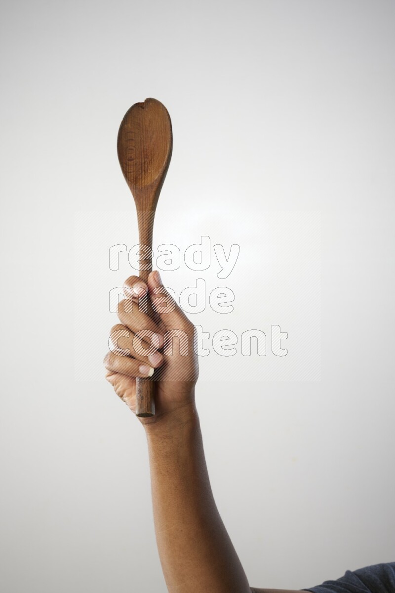 Male Hand Holding Wooden spoon on white background