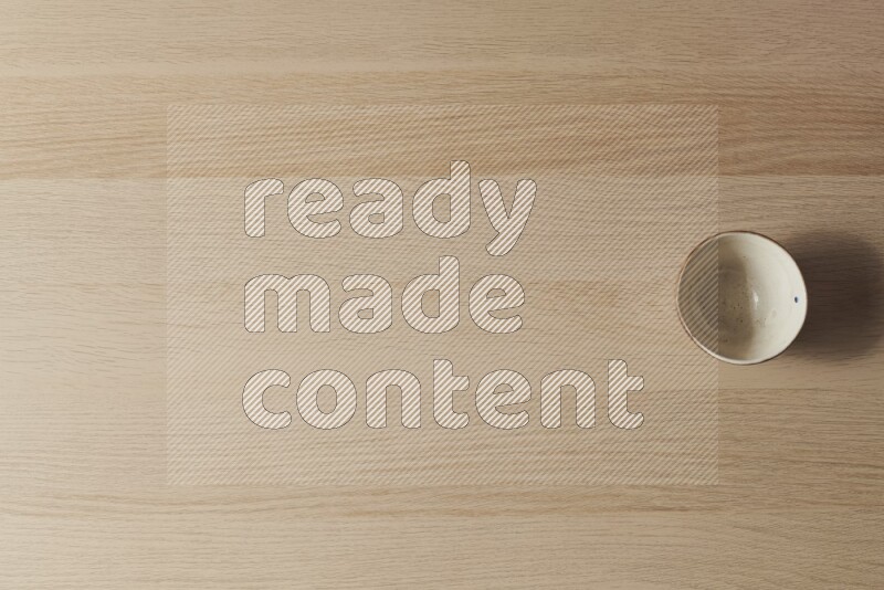 A white pottery bowl on light wooden background
