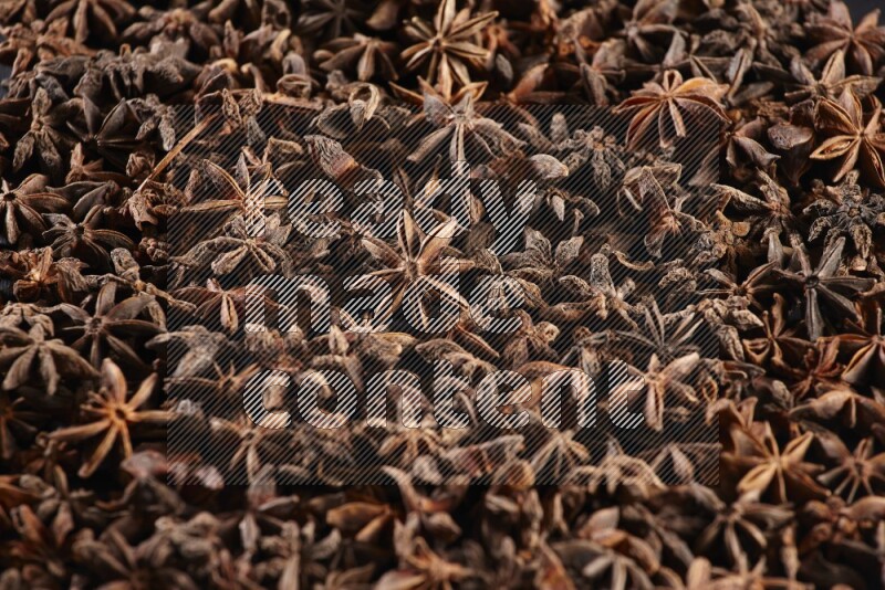 Star Anise herbs fill the frame on black flooring