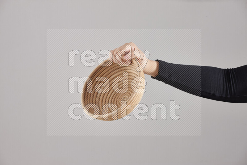 A woman in black abaya holding different wooden essentials in different positions
