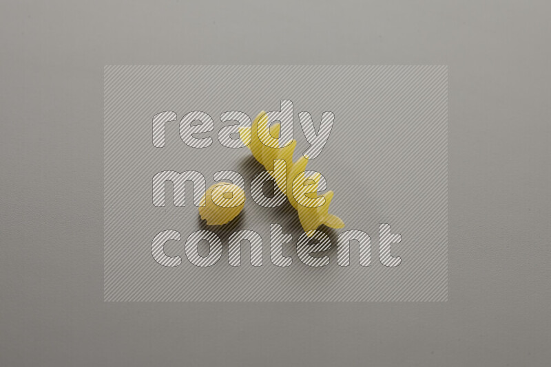 Shells pasta with other types of pasta on grey background