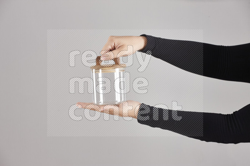 A woman in black abaya holding different glassware in different positions