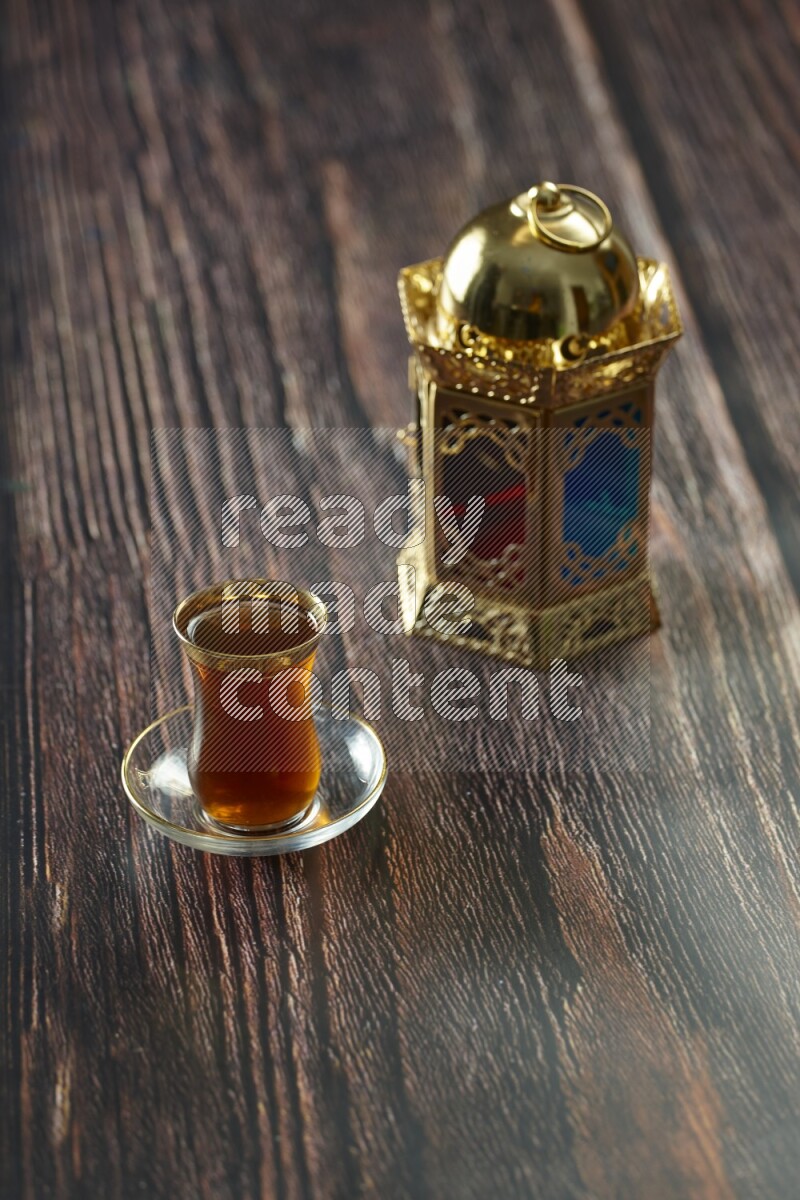 A golden lantern with different drinks, dates, nuts, prayer beads and quran on brown wooden background
