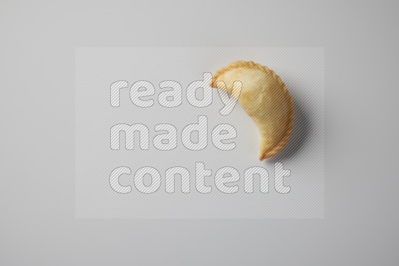 One fried sambosa from a top angle on a white background