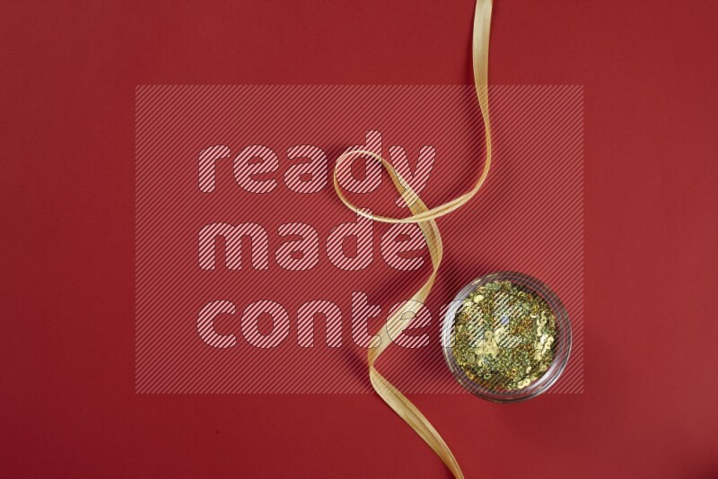 مجموعة من أدوات الخياطة والتفصيل صفراء اللون على خلفية حمراء