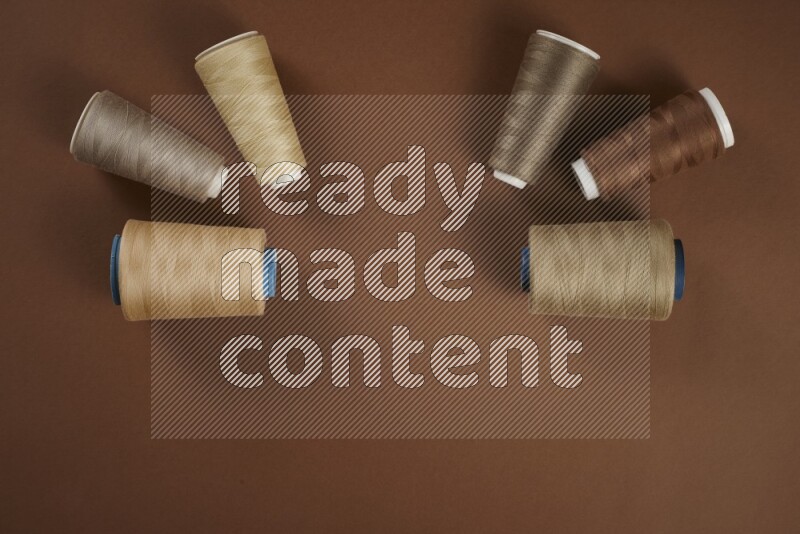 مجموعة من أدوات الخياطة والتفصيل بنية اللون على خلفية بنية