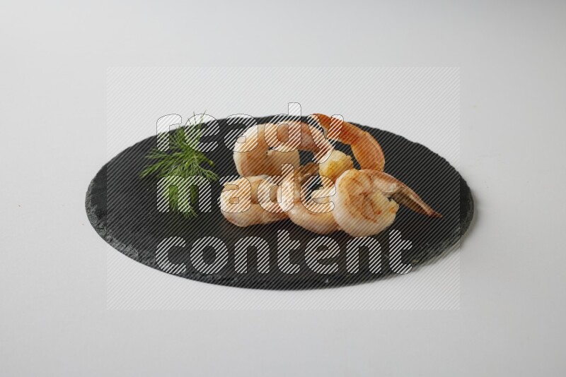 five grilled shrimps  on a black slate direct  on a white back ground