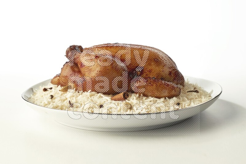 white  basmati Rice with  whole roasted chicken  on a white plate with a silver rim direct  on white background