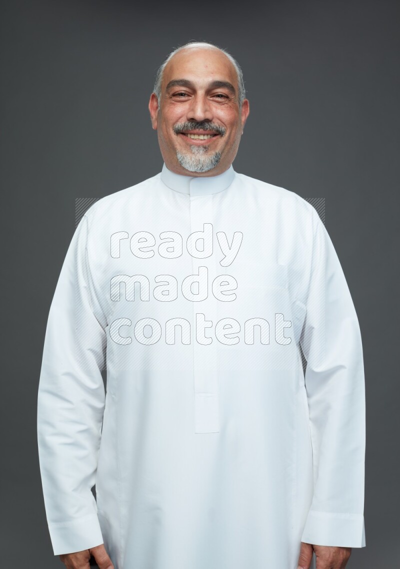 Saudi man without shomag Standing Interacting with the camera on gray background