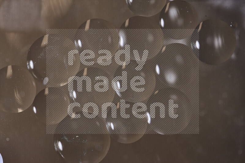 Close-ups of abstract oil bubbles on water surface in shades of brown