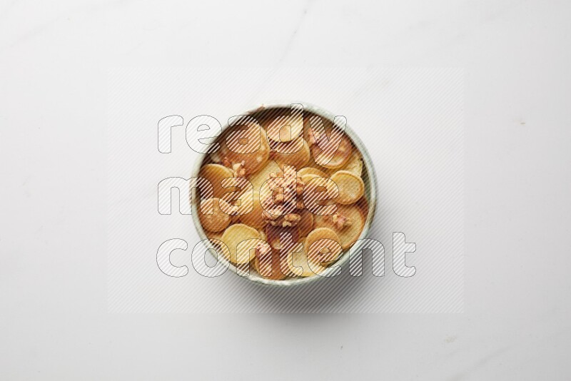 Top-view shot of walnut cereal pancakes in a round bowl on white background