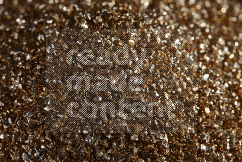 Gold shimmering fragments of glass scattered on a black background