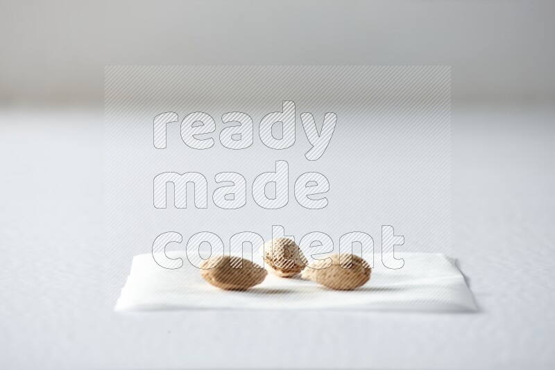 3 almonds on a piece of paper on a white background in different angles