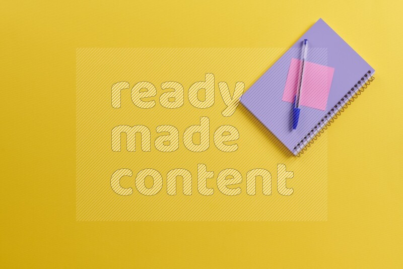 A purple notebook with different school supplies on yellow background