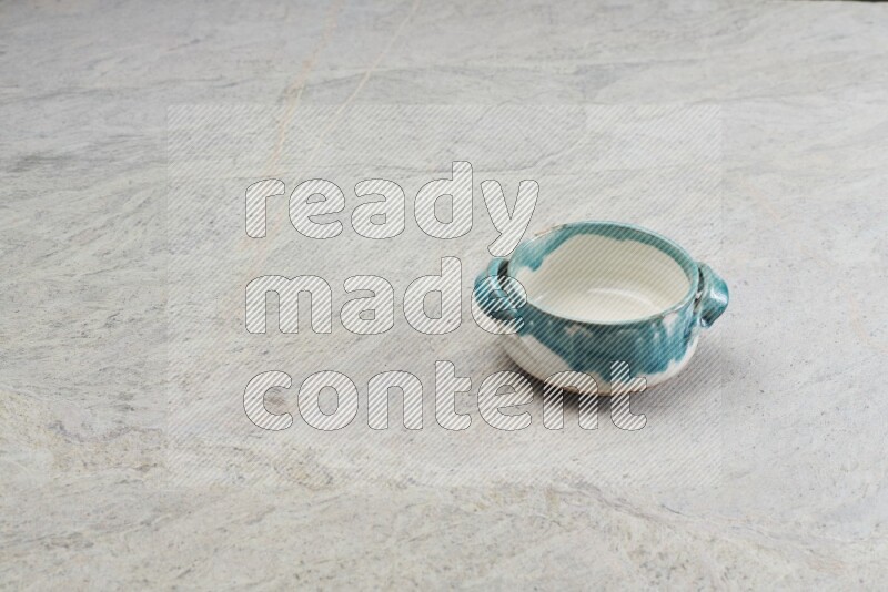A multicolored pottery bowl on grey marble background