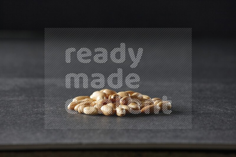 A bunch of peeled peanuts on a black background in different angles