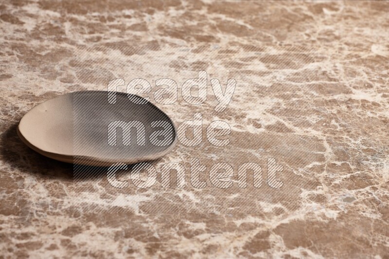 A multicolored pottery plate on beige marble background