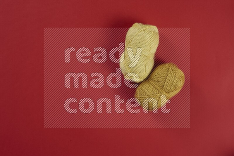 مجموعة من أدوات الخياطة والتفصيل صفراء اللون على خلفية حمراء