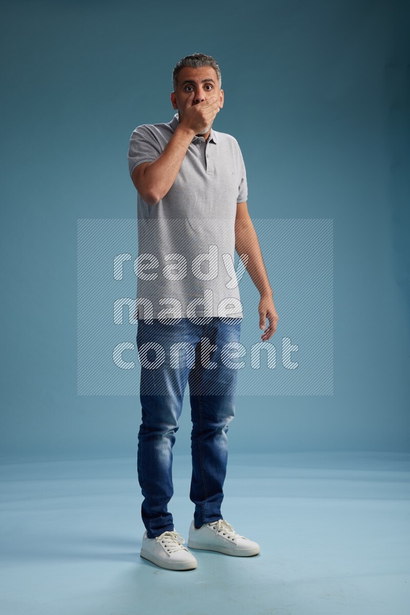 Man Standing Interacting with the camera on blue background