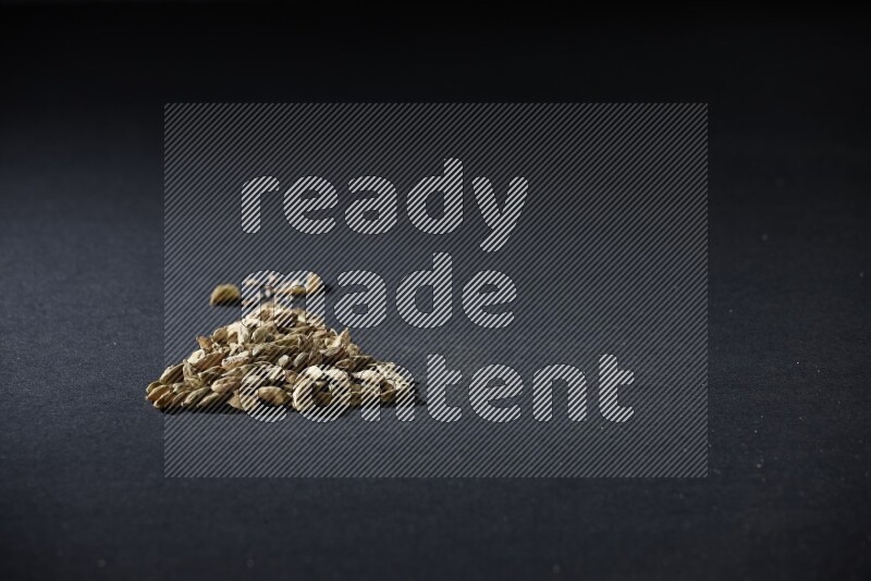 Cardamom in a triangle shape on black flooring