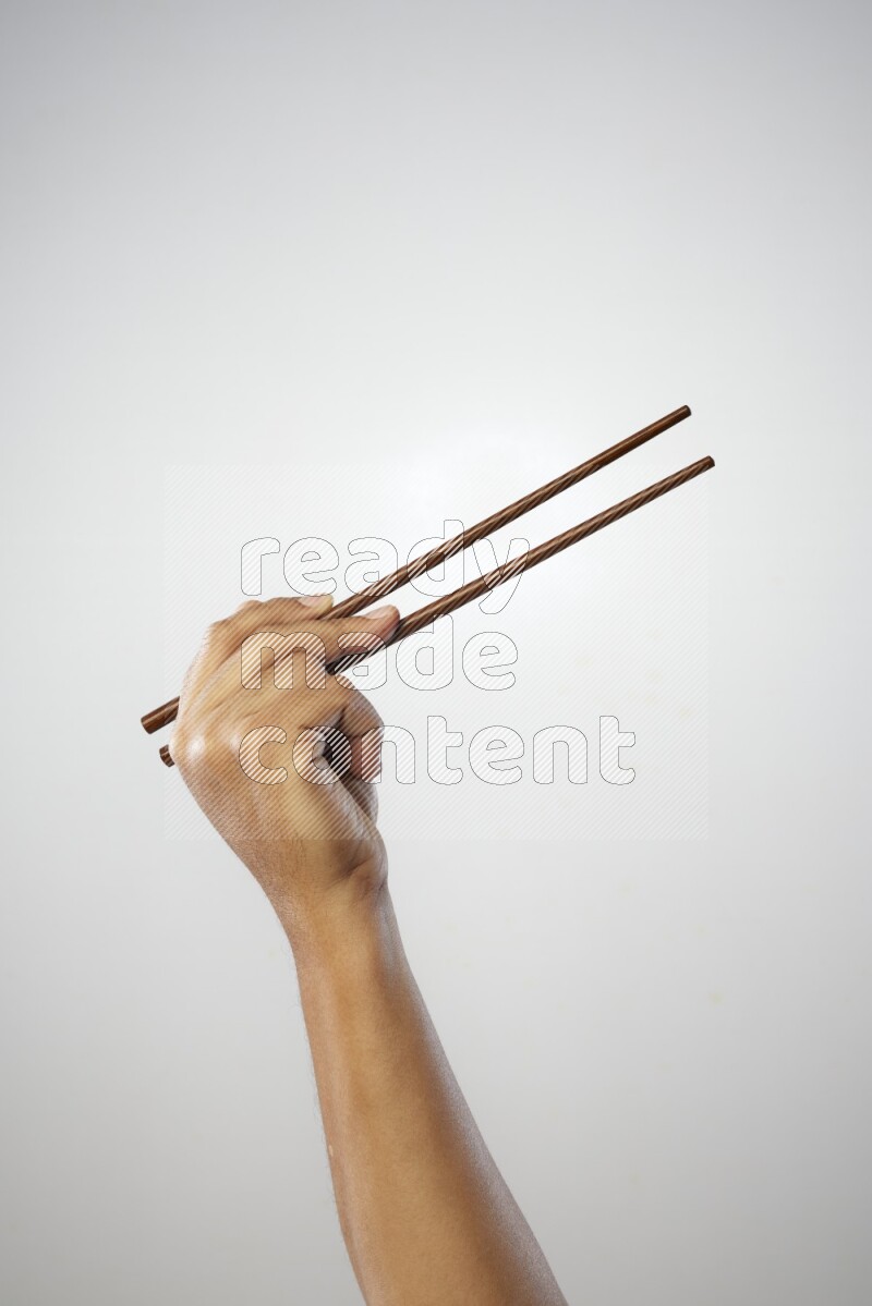 Male Hand Holding Chop Stick on white background