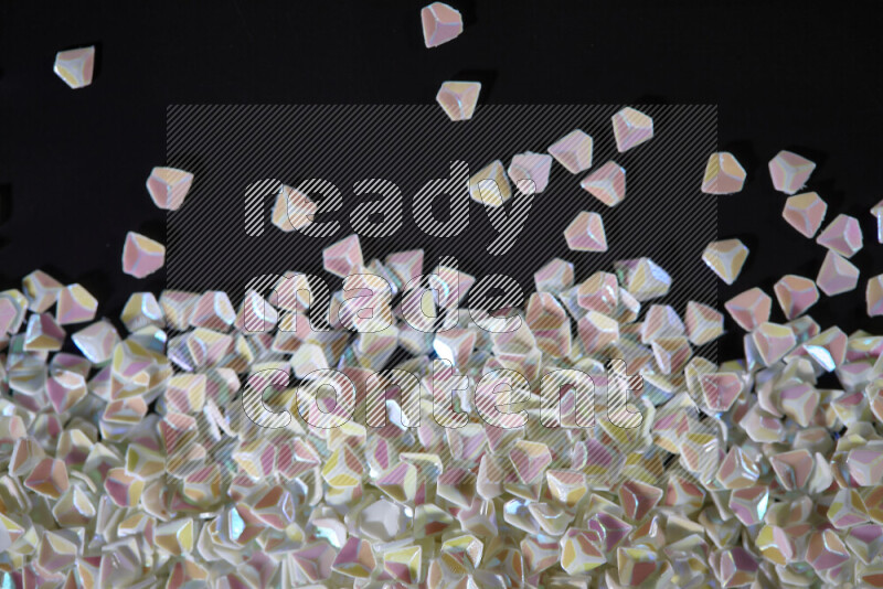 Colorful plastic shards for decoration scattered on a black background