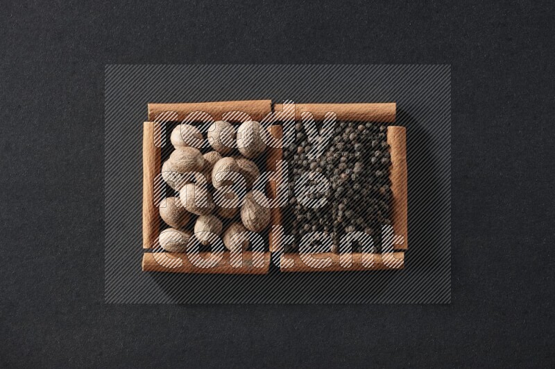 2 squares of cinnamon sticks full of nutmegs and black peppers on black flooring