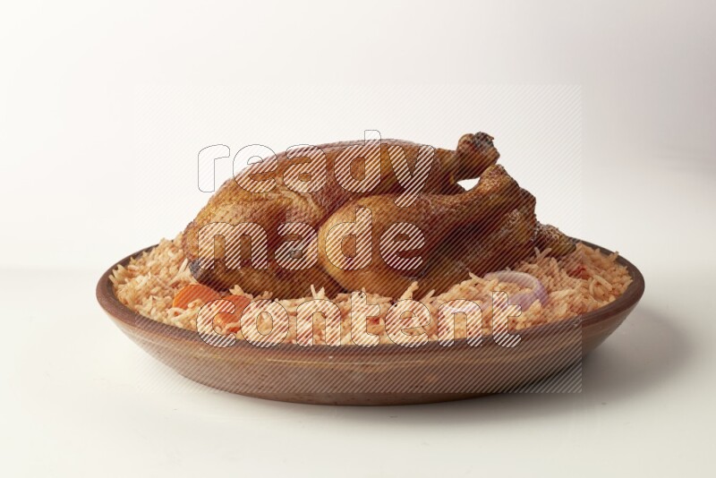 red basmati Rice with whole roasted chicken on a pottery plate direct on white background