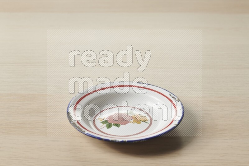 A vintage metal plate on light wooden background