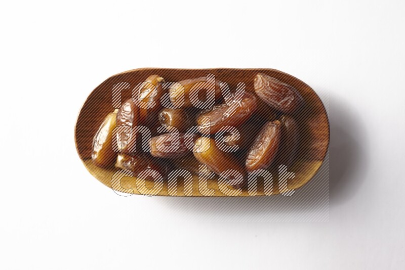Dates in a wooden plate on white background