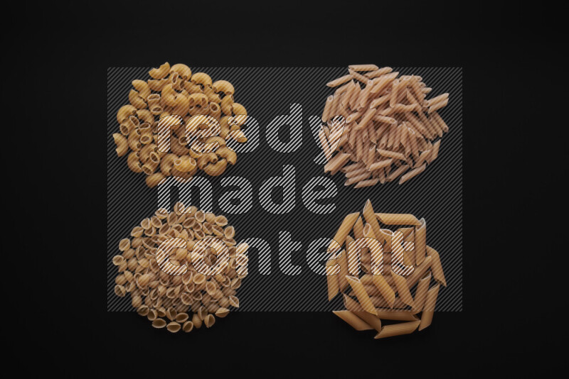 Different pasta types in bunches on black background