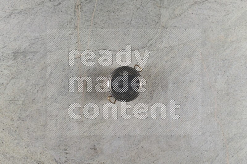 A small copper pot on grey marble background