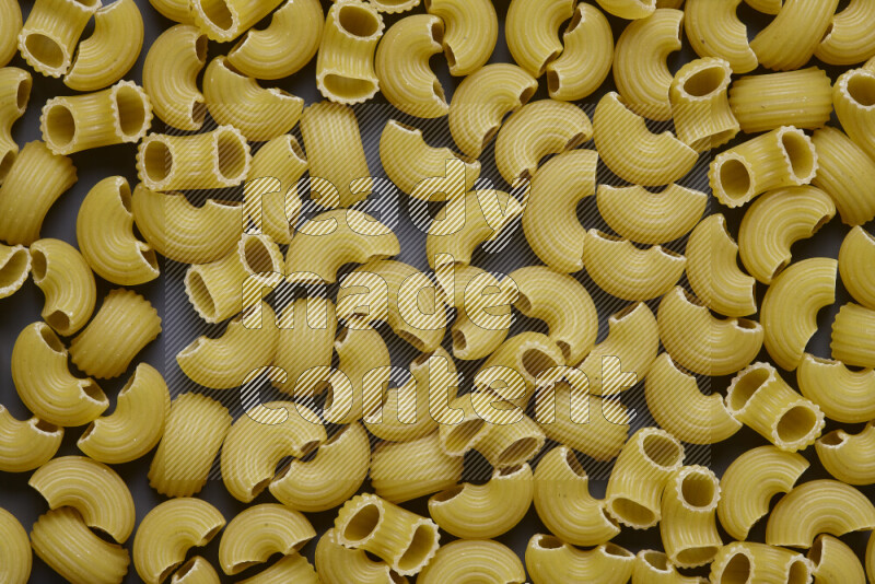 Elbow pasta on grey background