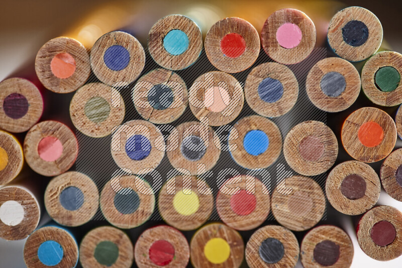 A close-up of the tips of colored pencils arranged in a bundle on white background