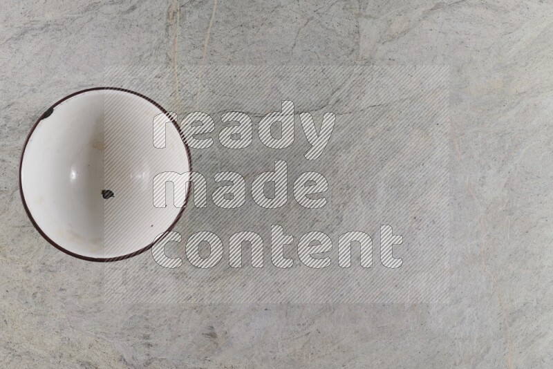 A vintage metal pot on grey marble background