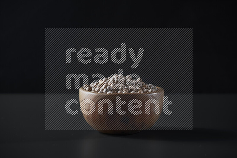 Chickpeas in a wooden bowl on grey background