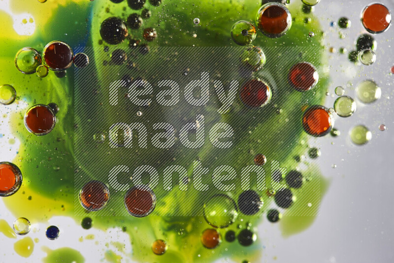 Close-ups of abstract red, blue, yellow and green watercolor drops on oil Surface on white background