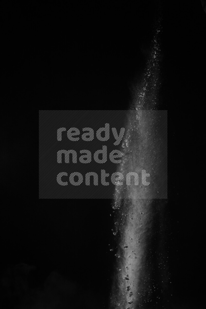 A side view of white powder explosion on black background