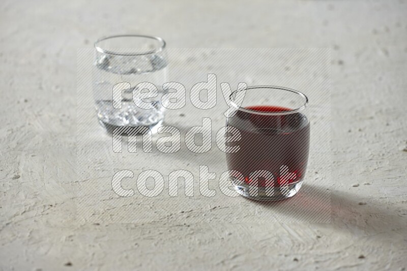 Cold drinks in a glass cup such as water, tamarind, qamar eldin, sobia, milk and hibiscus on textured white background