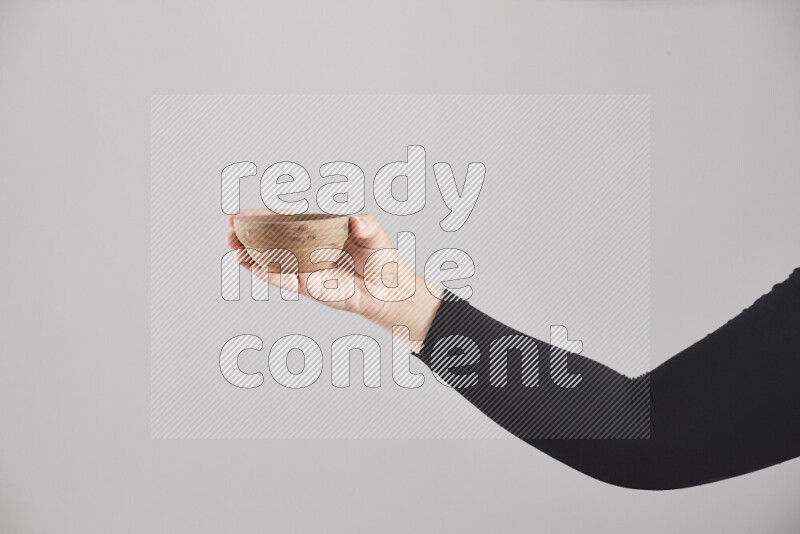 امرأة ترتدي عباءة سوداء تحمل أدوات خشبية مختلفة في أوضاع متعددة