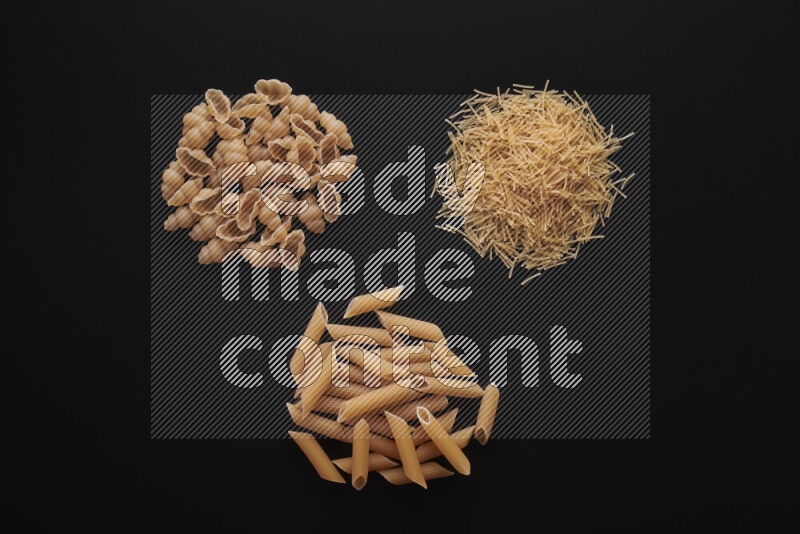 Different pasta types in bunches on black background