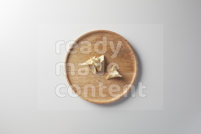 Three Sambosas on a wooden round plate on a white background
