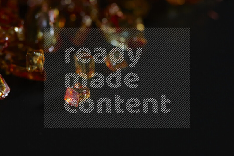 قطع زجاج برتقالية شفافة متناثرة على خلفية سوداء