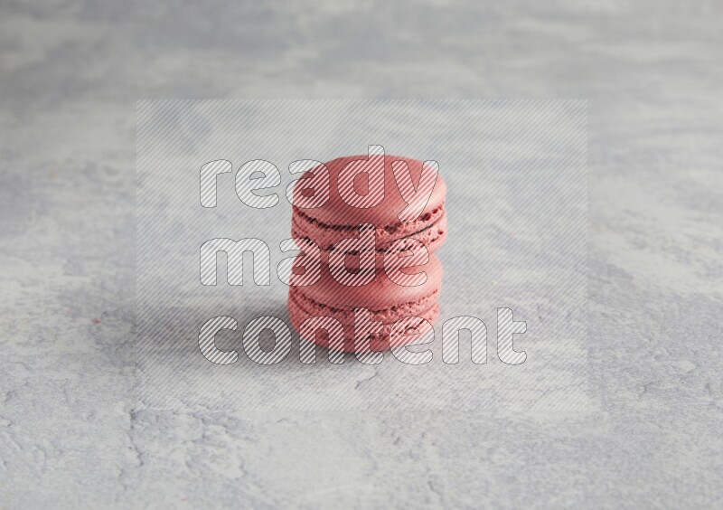 45º Shot of two Pink Raspberry macarons  on white  marble background