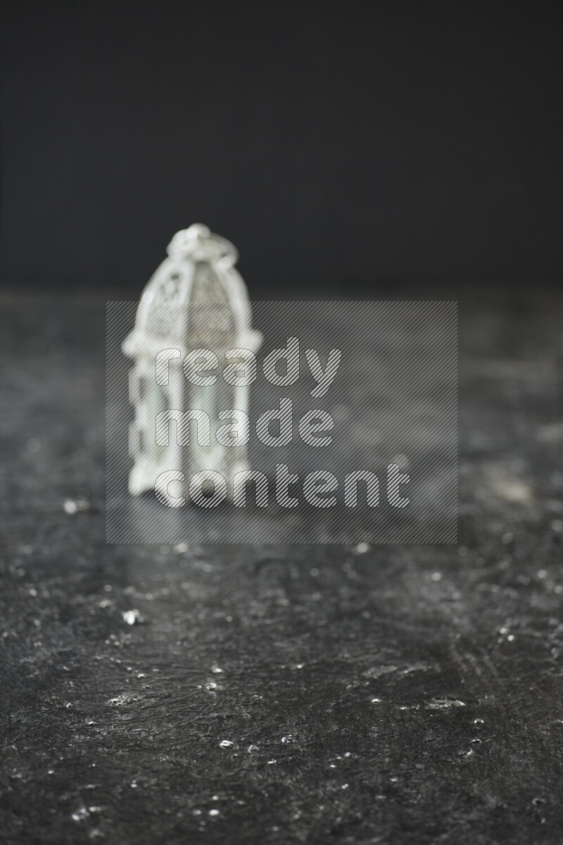 A lantern placed on a textured black background