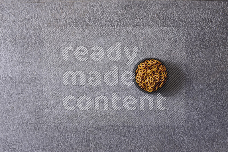 Assorted snacks in pottery bowls on grey background
